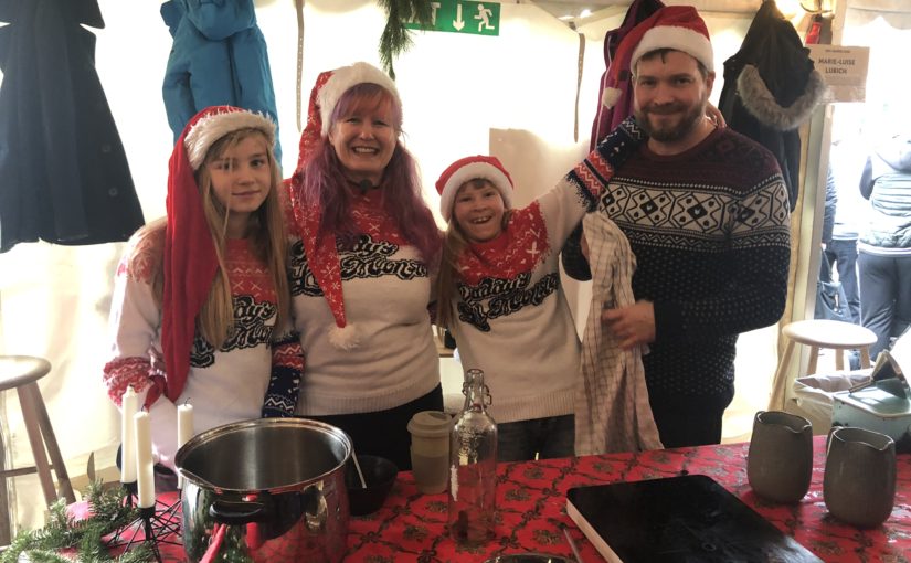 image of a family group dressed up in christmas garb presiding over a cauldron of gløgg
